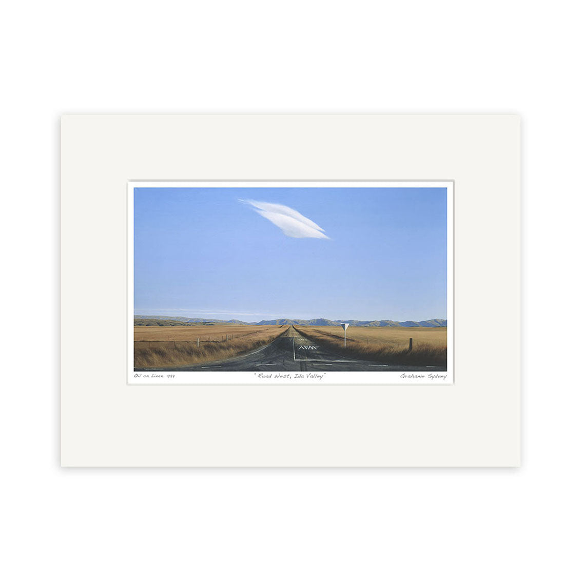 The Grahame Sydney - Road West, Ida Valley Small Art Print features a two-lane rural road stretching through flat grassy fields beneath a blue sky with a single white cloud and distant mountains in the background.