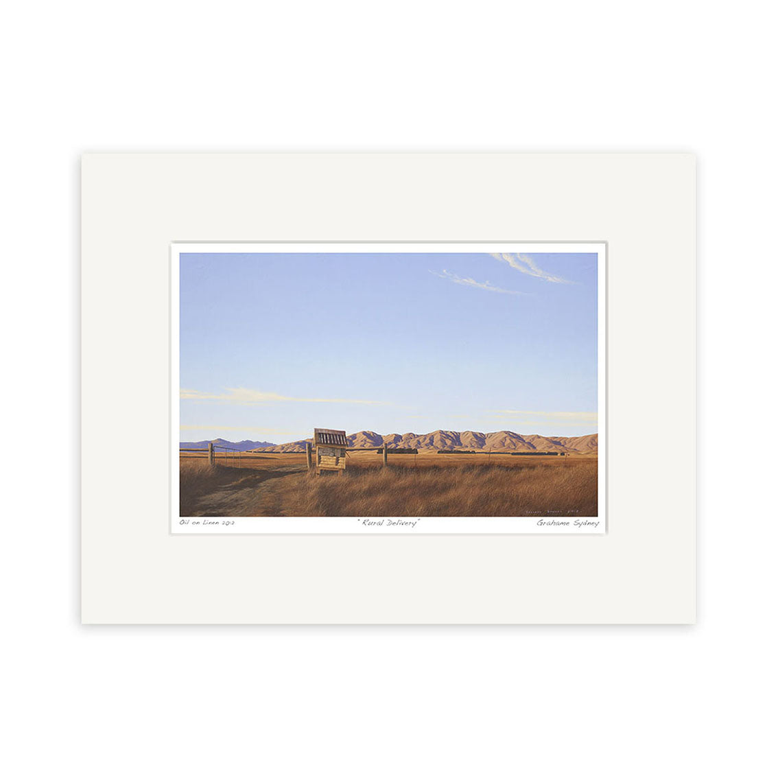 The Grahame Sydney - Rural Delivery Small Art Print features a grassy field with a wooden structure in the foreground and distant mountains beneath a blue, cloud-streaked sky, inspired by New Zealand artist Grahame Sydney.