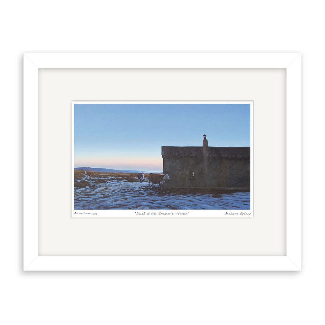 The Grahame Sydney - Dusk at Shearers Kitchen Small Art Print features a solitary house on a snowy plain at dusk or dawn, with long shadows and a pastel sky. Faint details near the house add intrigue. The print comes in a white frame.