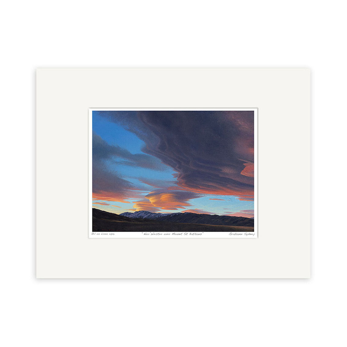 A small matted art print titled Norwester over Mt St Bathans by New Zealand artist Grahame Sydney, featuring a sunset sky with blue, orange, and purple clouds above distant mountains. The artwork is centered within a white mat.