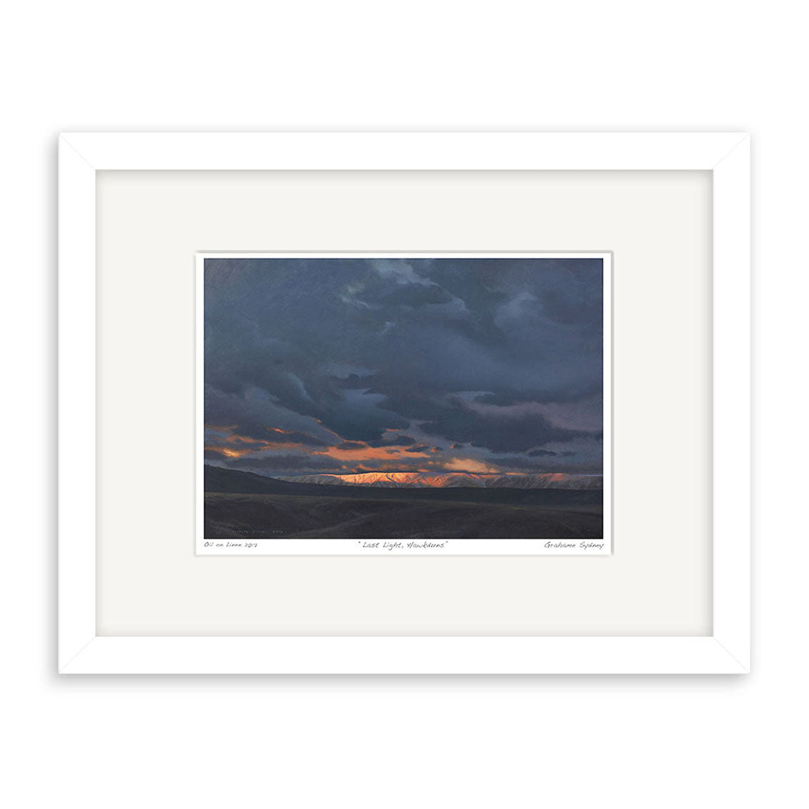 The Grahame Sydney - Last Light Hawkduns Small Art Print features a dramatic landscape with dark clouds and a strip of orange sunlight over distant mountains, presented in a white frame with wide white mat—perfect for any art collection.