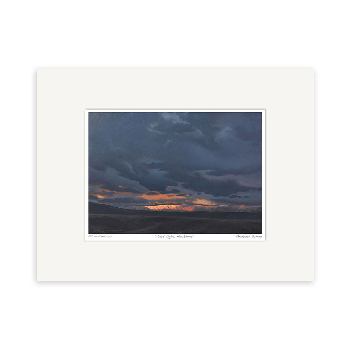 The Grahame Sydney - Last Light Hawkduns Small Art Print features dark, cloudy skies above distant mountains and a slim orange horizon band, all bordered by a white mat—an ideal addition to any art collection.