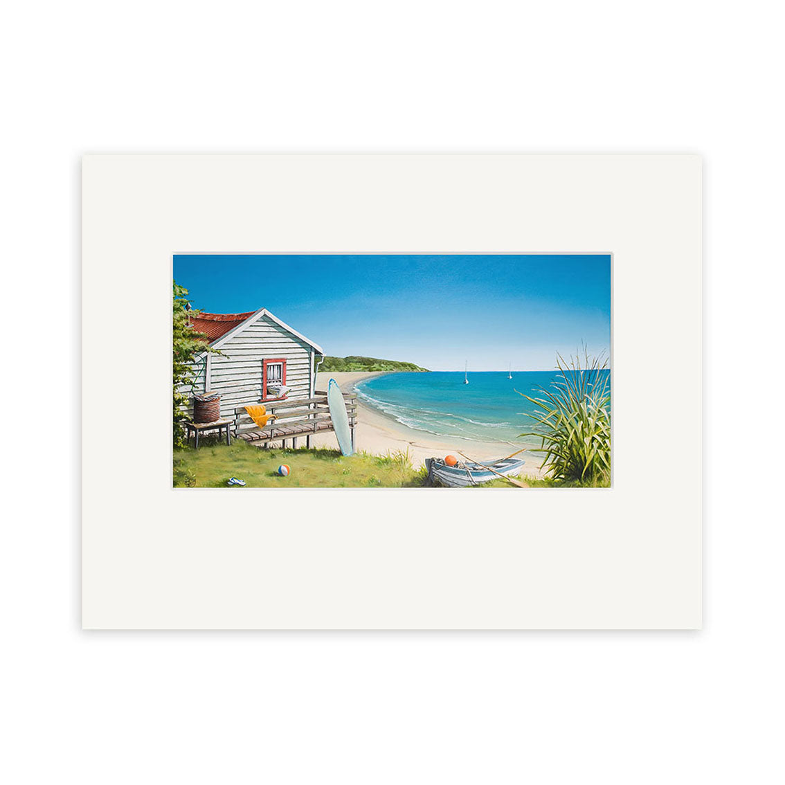 The Graham Young - Bach by the Beach Small Art Print features a wooden beach hut with a surfboard, surrounded by grass and plants, set against a calm blue sea with sailboats—artfully captured by New Zealand artist Graham Young.