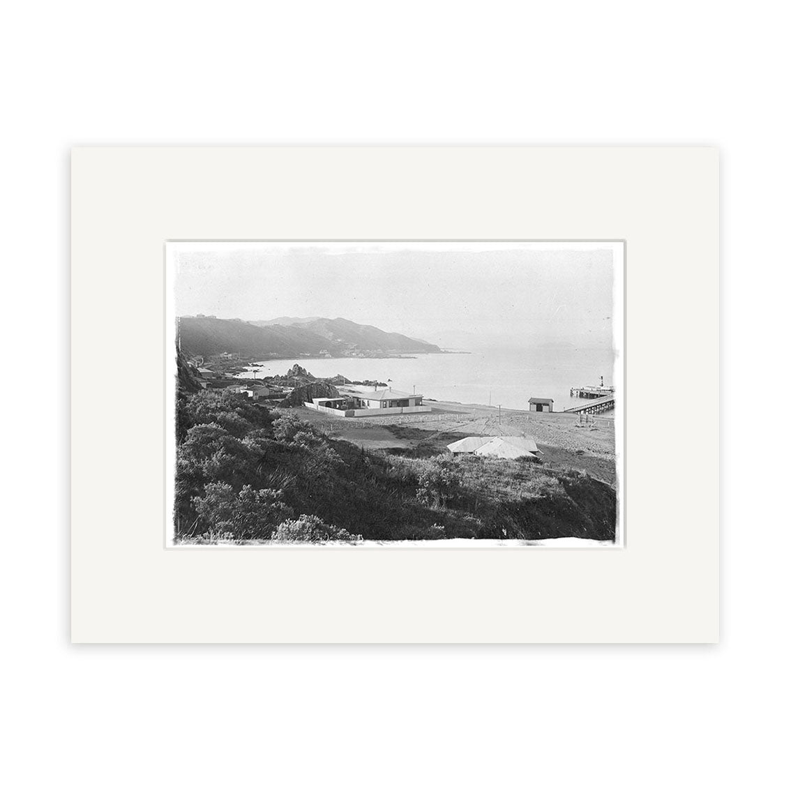 Black and white photograph titled Seatoun 1904 - HI022 shows a coastal landscape with shoreline buildings, distant hills, and the ocean. Printed on archival quality matte paper as a Historical Photographic Print made in New Zealand.