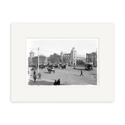 Cathedral Square 1910 - HI026: Archival quality black and white photo depicting a bustling early 20th-century New Zealand city street with pedestrians, horse-drawn carriages, vintage cars, and a domed building in the background.