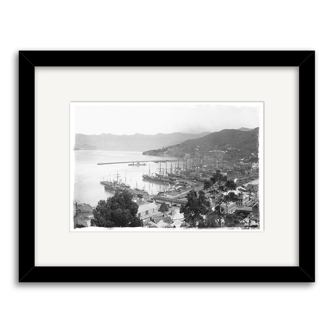 Black and white framed Lyttelton 1890 - HI036 Historical Photographic Print of New Zealands harbor with docked ships, waterfront buildings, and hills, seen from above, printed on archival quality matte paper.