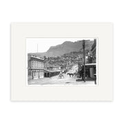 The London St Lyttelton 1916 - HI037 black-and-white historical photographic print shows a street scene with horses, carriages, and lined buildings against hills. Printed on archival quality matte paper.