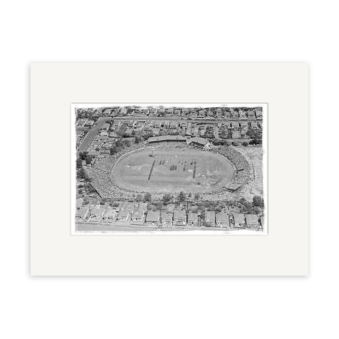 An archival-quality black-and-white aerial photo print of Eden Park 1950 (HI039), a crowded oval sports stadium in New Zealand, surrounded by houses with spectators in the stands and activity on the field.