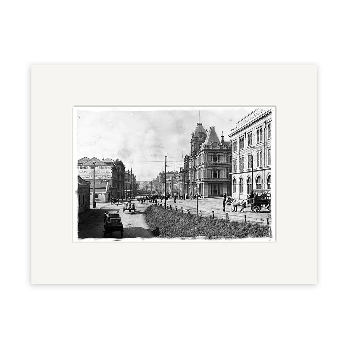 Archival quality black and white photographic print, Custom St 1910 - HI044, features a New Zealand city street scene from the early 1900s with people, horse-drawn carriages, early automobiles, and ornate buildings with a clock tower.