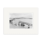 HarbourBridge 1958 - HI054: A black-and-white historical photo print of a partially collapsed steel bridge over water with boats and land, printed on archival matte paper. Made in New Zealand.