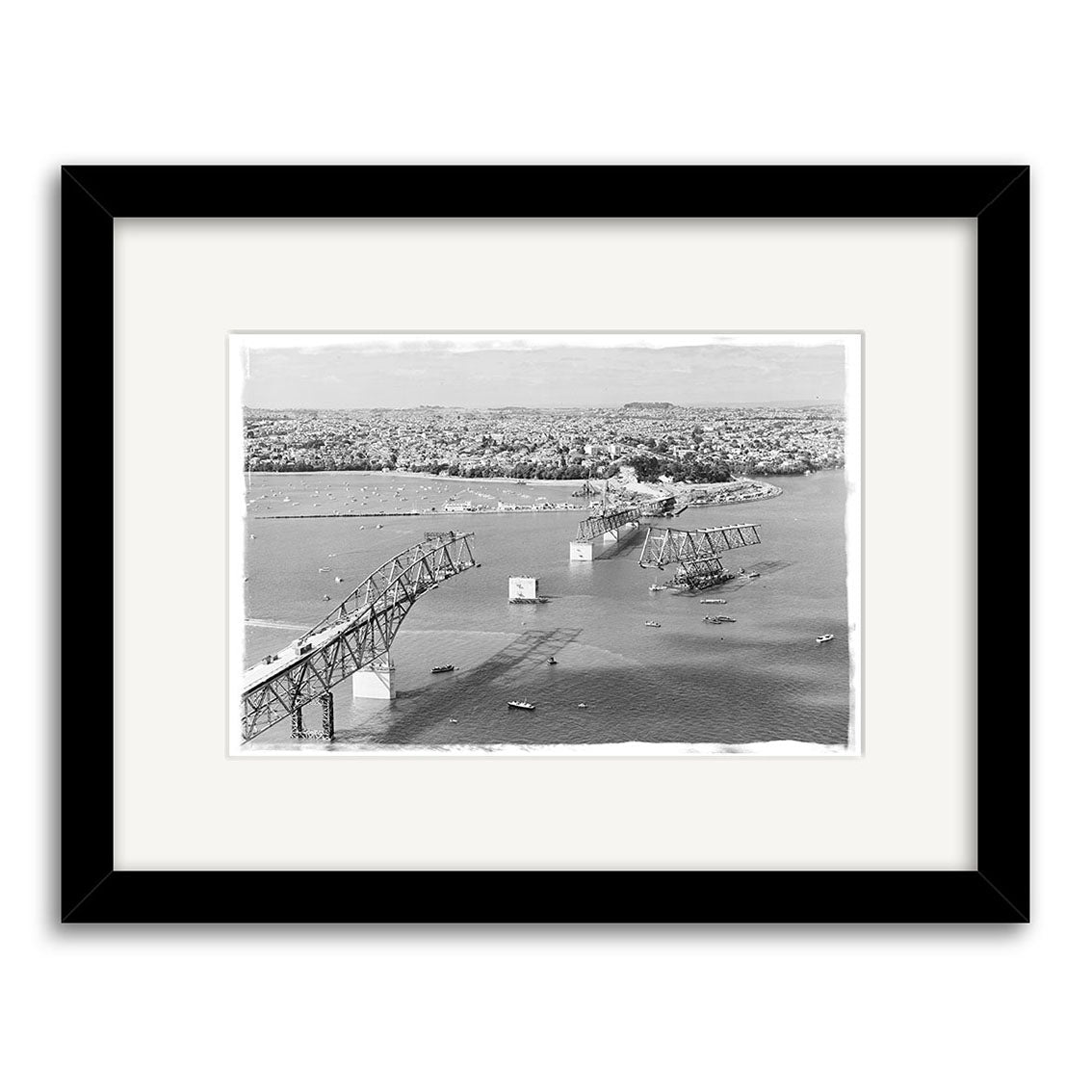 Black and white historical print Harbour Bridge 1958 - HI055 shows a partially collapsed bridge over water with boats below and a cityscape behind. Printed on archival matte paper, framed with a white mat and black border.