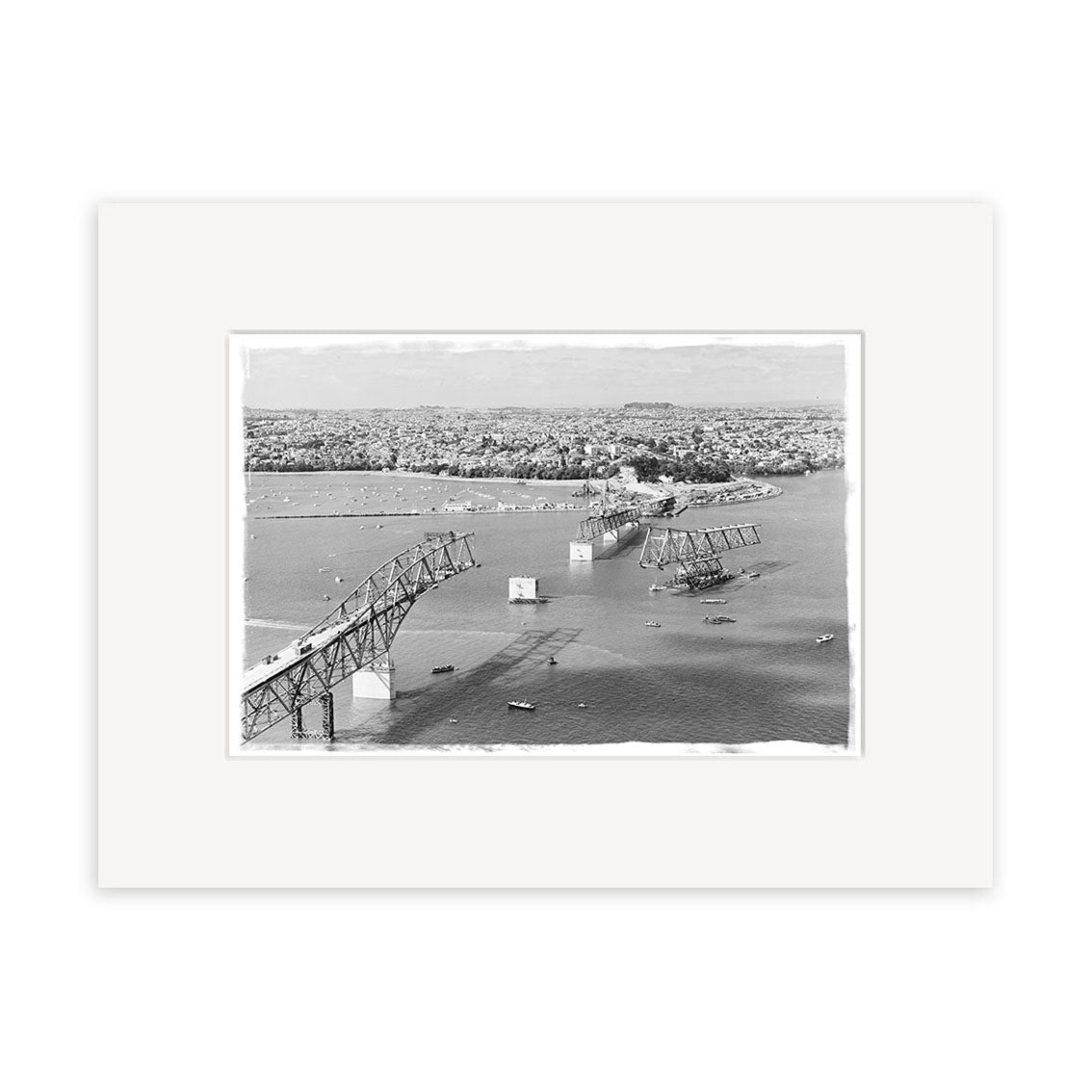 Harbour Bridge 1958 - HI055: Black and white historical photo print of a partially collapsed bridge over water with cityscape in the background. Printed on archival quality matte paper, made in New Zealand.