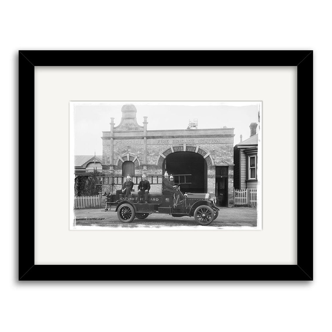 Ponsonby Fire Station 1919 - HI057: Archival-quality black and white print of an old-fashioned fire engine with two uniformed men in front of the Ponsonby Fire Brigade Station, elegantly matted in white and framed in black.