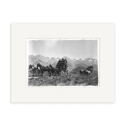 Archival quality black and white photo, Christchurch Rd Cass 1900 - HI062, shows two horse-drawn stagecoaches with several people aboard crossing a New Zealand plain, snow-capped mountains in the background.