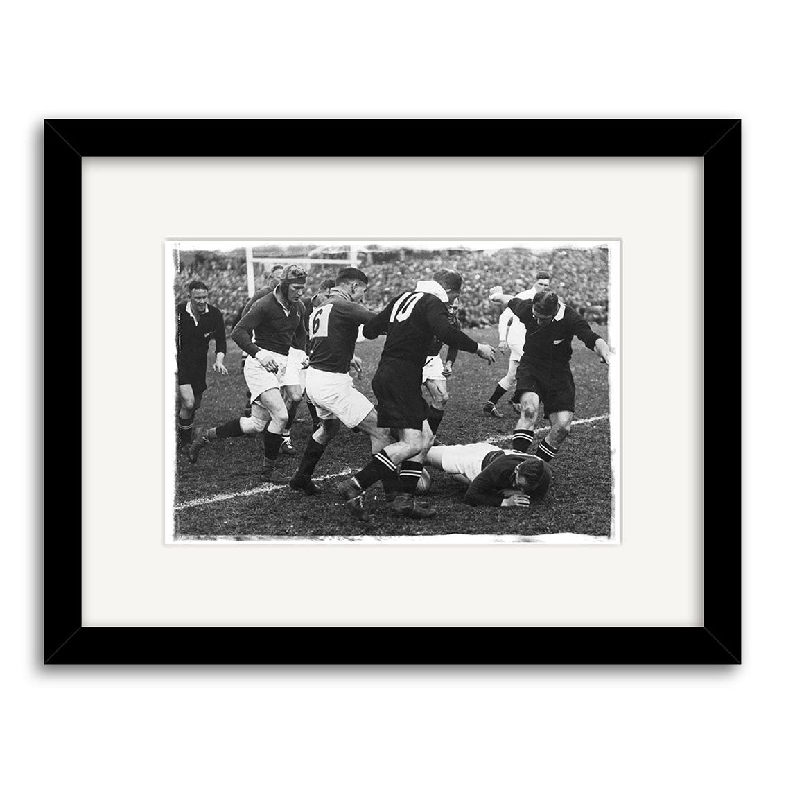 A black and white archival print titled All Blacks vs Springboks 1937 - HI066 shows rugby action, with a player on the ground holding the ball. Displayed in a black frame with white mat. New Zealand.