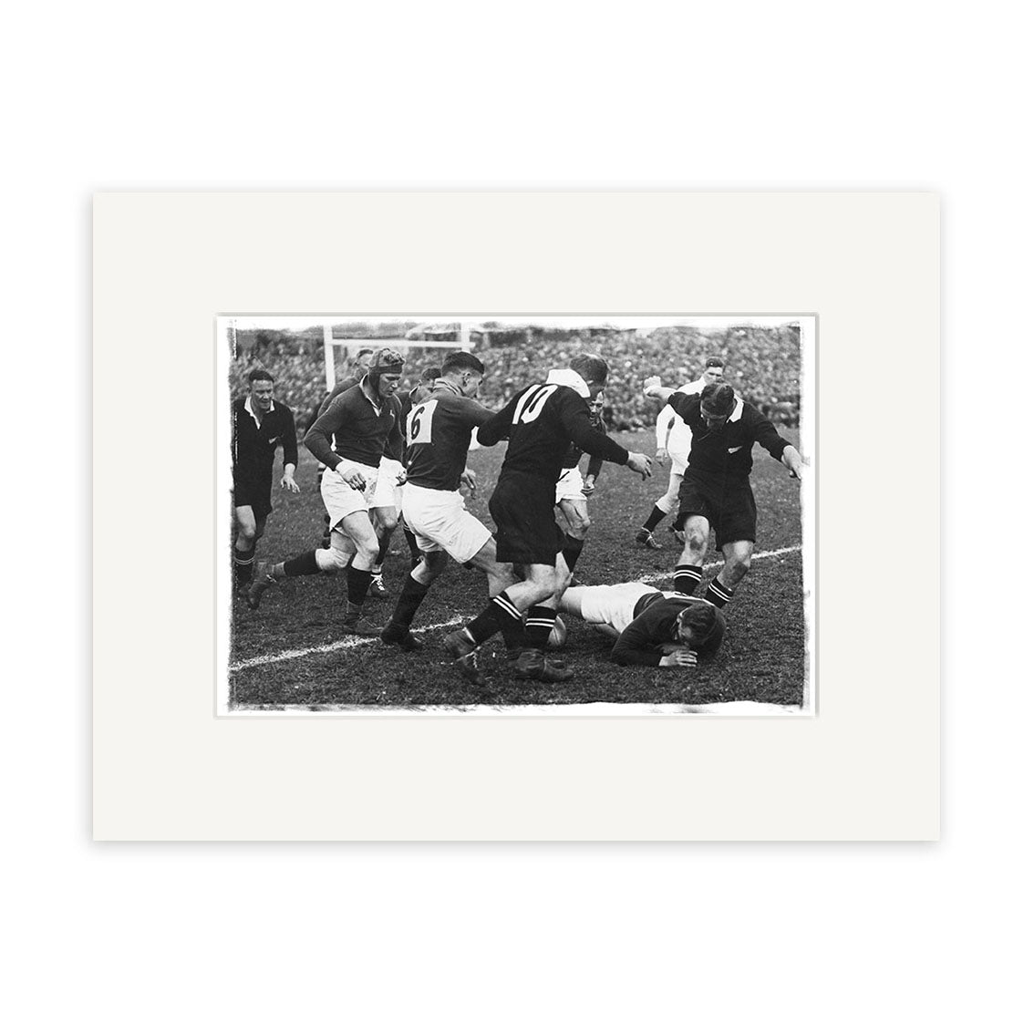 The All Blacks vs Springboks 1937 - HI066 is a black and white historical photographic print capturing players in dark uniforms mid-rugby match, tackling and running on a grassy New Zealand field.