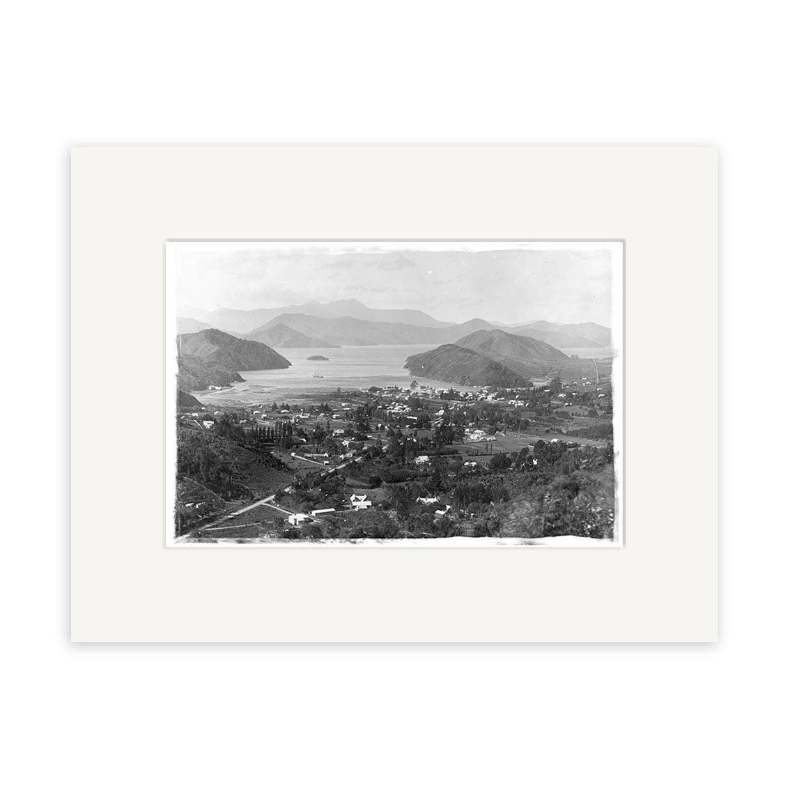This archival-quality Marlborough Sounds 1896 - HI071 print shows a black-and-white aerial view of a small town with houses, roads, and trees amid hills, water, and distant mountains. Printed on matte paper.