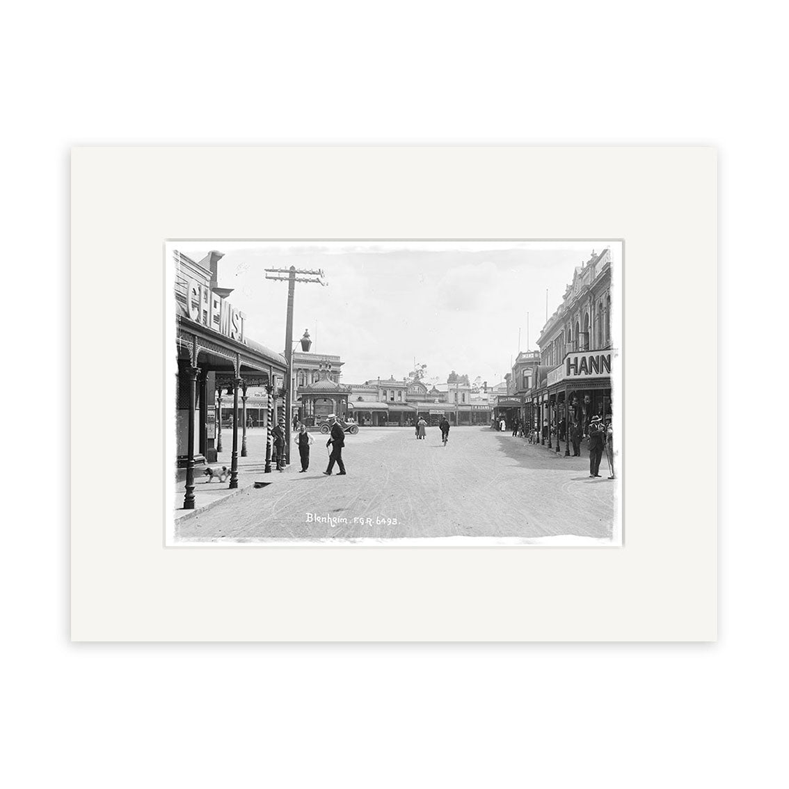 Archival quality Historical Photographic Print: black and white photo of a wide street scene labeled “Market Place 1911 - HI073,” New Zealand, showing pedestrians, shops on both sides, and visible shop signs.