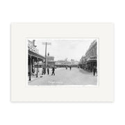 Archival quality Historical Photographic Print: black and white photo of a wide street scene labeled “Market Place 1911 - HI073,” New Zealand, showing pedestrians, shops on both sides, and visible shop signs.