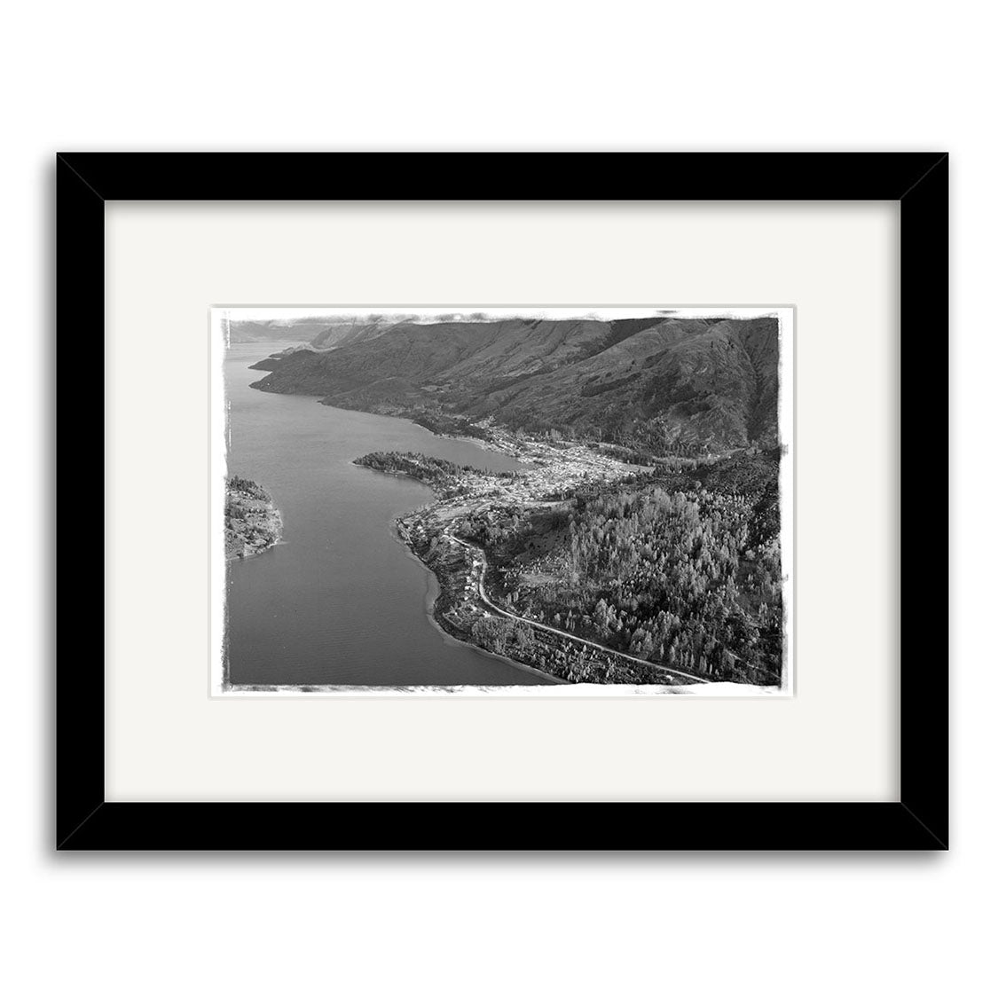 A black and white aerial photo titled Queenstown 1957 - HI108 shows a town between a lake and forested hills, with winding shoreline roads. This framed Historical Photographic Print is made in New Zealand.