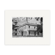 Black and white archival photo print of Eichardts Hotel, 1910 (HI118), a historic two-story building on a corner. Foreground includes streetlamp and tree branches. Labeled “Eucharda Hotel, Queensland, Parson’s Stores.”.