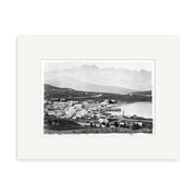 A historical black and white photo titled Queenstown 1880 - HI122, showing a small New Zealand town by the water with buildings along the shore and hills behind, printed on archival matte paper.