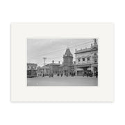 Black and white historical print Post Office 1925 - HI126 shows a tranquil New Zealand town square with a tram, people, clock tower, and ornate buildings. Printed on archival matte paper for lasting beauty.
