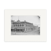 This archival quality matte print features a black and white photo of the two-story Briscoe & Co Ltd building from the 1890s (HI134), captured in New Zealand, with ornate details and a white mat border.