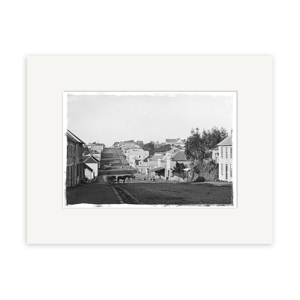 Devon St 1860 - HI146: Black and white historical photographic print of a 19th-century street with houses, horse-drawn cart, and trees. Framed with a white mat on archival-quality matte paper.