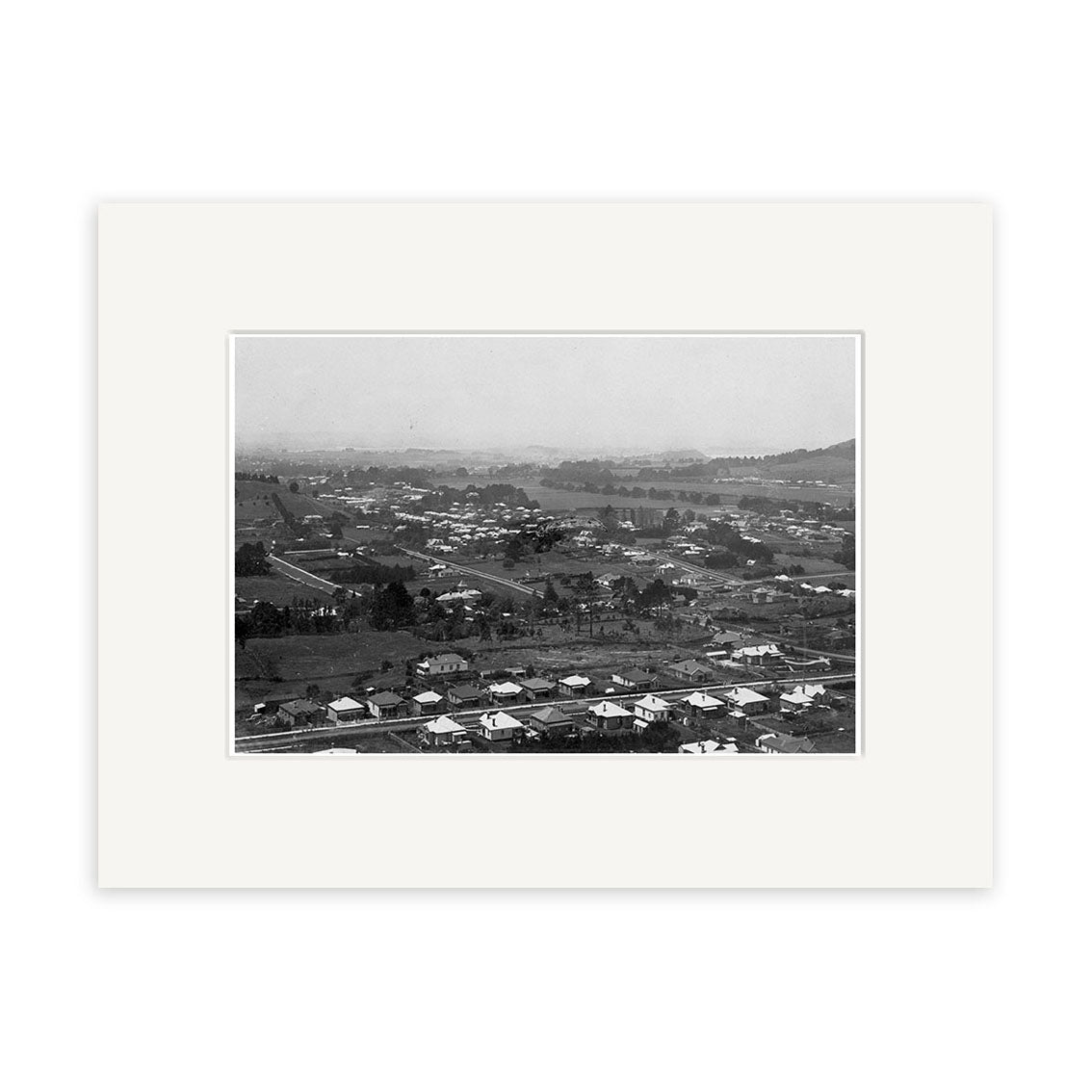 The Epsom 1907 No.1 - HI153 is a black and white aerial photograph of a New Zealand suburb, showing houses, roads, trees, and hills. This historical print is presented in a white mat frame for archival quality display.