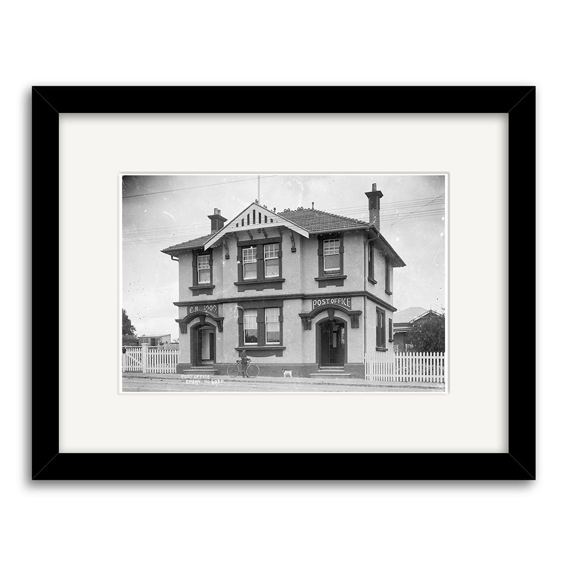 Black and white photo titled Epsom Post Office 1910 - HI154 shows a two-story building with Post Office and Erskineville signs, framed with a black mat on a white background. Printed in New Zealand on archival quality matte paper.
