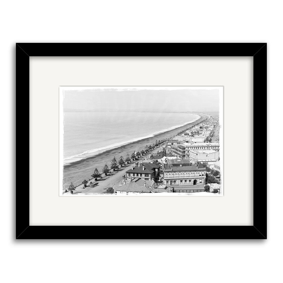 Archival-quality black and white aerial photo print of Napier 1890 (HI168), showing the coastal city’s streets, shoreline, and ocean. Displayed in a black frame with white mat.