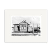 Post Office 1910 - HI182: Black and white historical photographic print of a small gabled-roof post office with Post Office sign, picket fence, lamp post, and street in front. Printed on matte archival-quality paper.