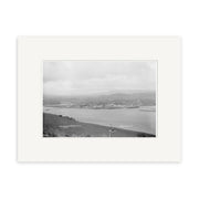 Raglan 1910 No.1 - HI184: Black-and-white historical photographic print of a coastal landscape with water, buildings, hills, and cloudy skies; labeled locations. Printed on archival quality matte paper.
