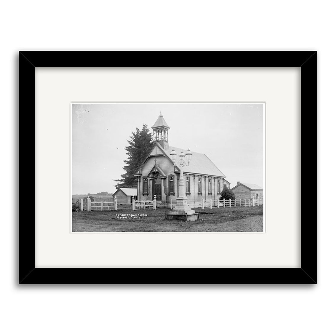 Black-and-white historical photographic print of St James Presbyterian Church 1915 (HI201), a small church with steeple, surrounded by a fence and trees. Labeled in white text, the photo is archival-quality framed with a wide white mat.