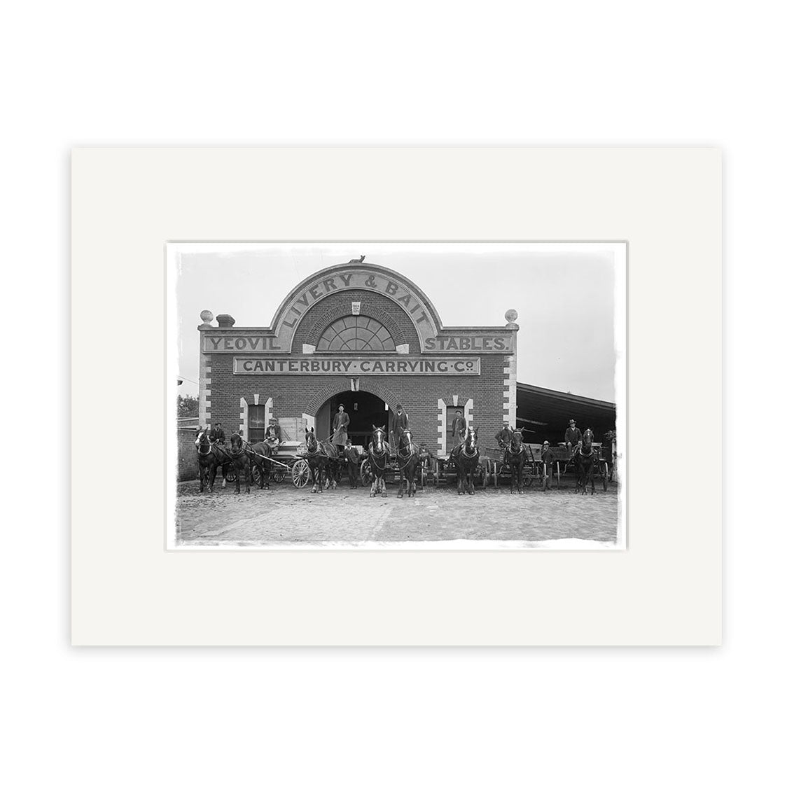 Black and white historical photo titled Canterbury Carrying Company 1910 - HI204 shows people with horses and carriages outside a brick building marked Yeovil Livery & Bait Stables and Canterbury Carrying Co.