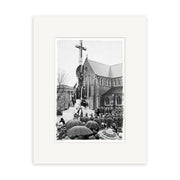 The War Memorial 1937 - HI208 features an archival black-and-white photo of a crowd with umbrellas outside a New Zealand stone church. A large cross stands in front, and several people are seen on a platform at its base.