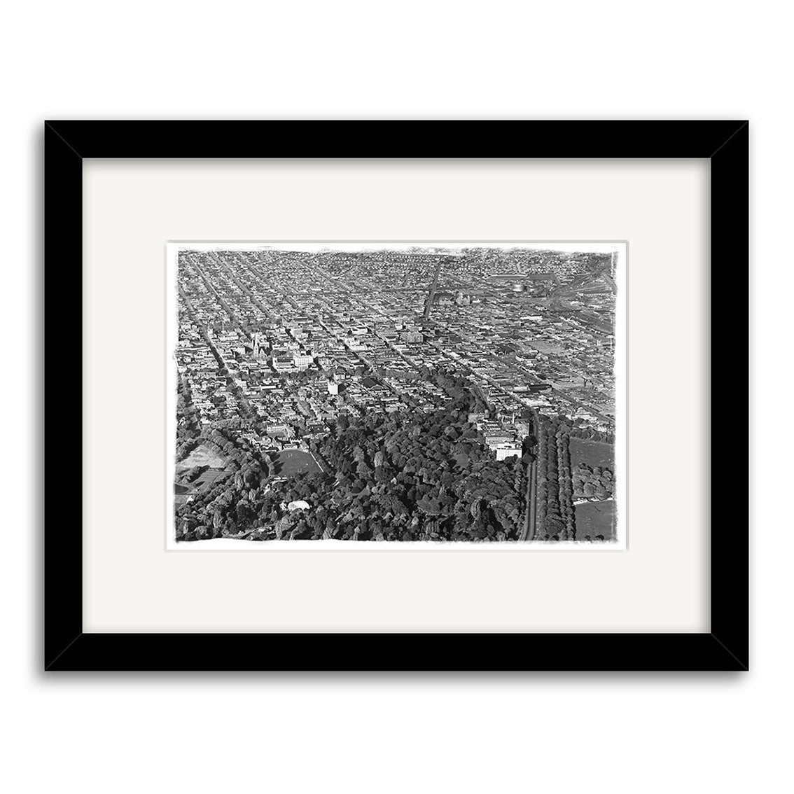 Christchurch 1950 - HI213: Black and white aerial photo of a New Zealand city featuring a large park, buildings, and distant streets. This historic photographic print is framed with a white mat and black border.