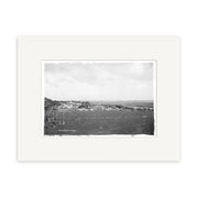 Helensville 1914 No.2 - HI215 is a black and white photographic print of a rural New Zealand landscape with a small town, open fields, and a partly cloudy sky, framed with a wide white mat.