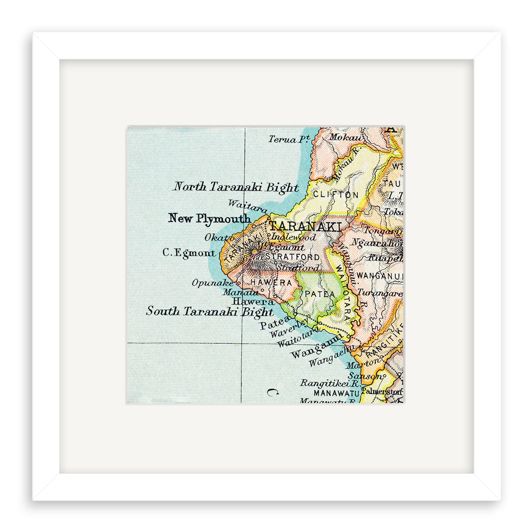 The Taranaki Vintage Map Print is a framed giclee featuring a lithograph segment of New Zealands Taranaki region, highlighting towns like New Plymouth, Stratford, and Hawera. Presented centered within a white mat and frame.