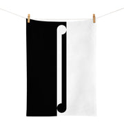 The Gordon Walters - Maho Tea Towel, featuring a black and white split design inspired by the New Zealand artist, hangs from a clothesline with clothespins and is divided vertically by a white bar with rounded ends.
