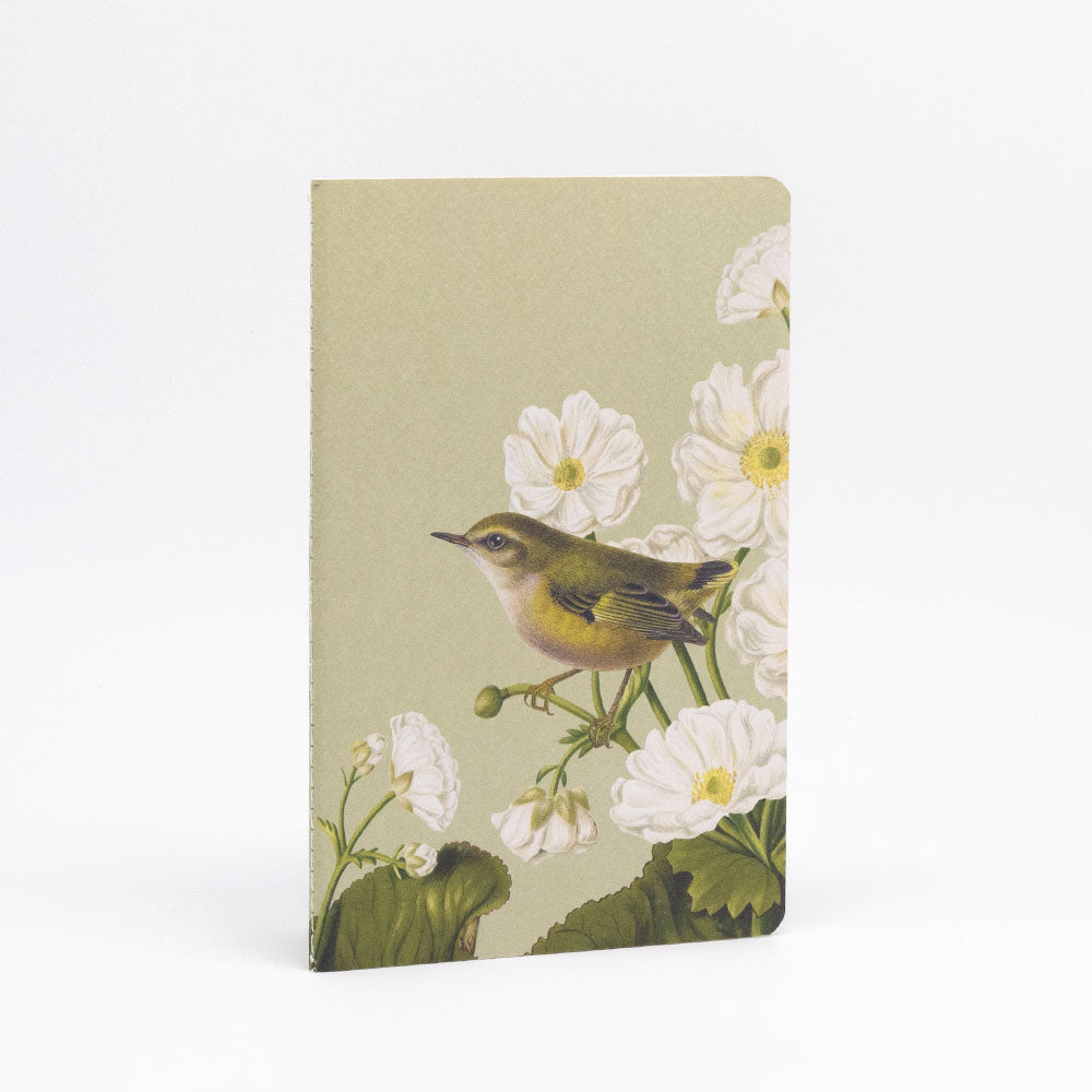 The Birds & Botanicals Notebook Set features a lined notebook with hand-stitched binding and a cover depicting a small bird among white flowers and green leaves on beige, photographed upright against a plain white background.
