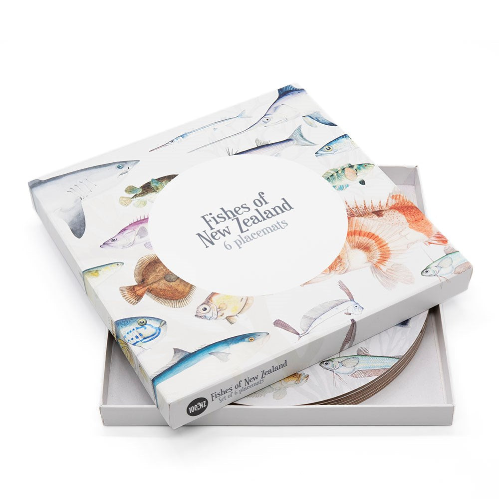 The Fishes of NZ Box of 6 Placemats features illustrated fish on the cover; the box is partially open to show cork-backed placemats inside, each with matching fish artwork. Designed in New Zealand.