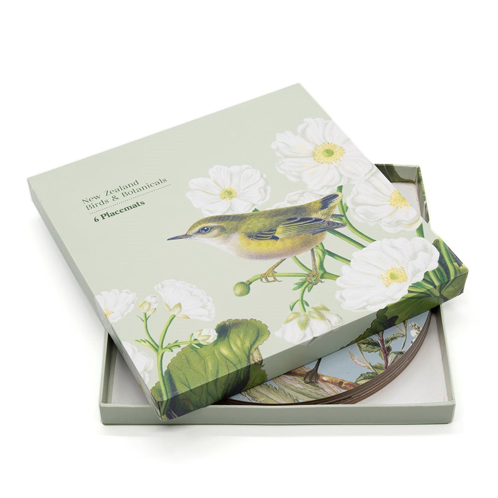 A partially open Birds & Botanicals of NZ Box of 6 Placemats reveals round mats inside, with packaging featuring a bird and white flowers on a pale green background.