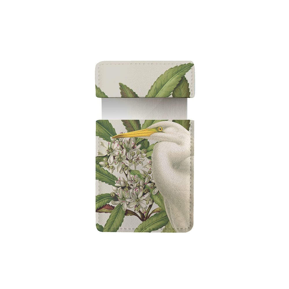 The Birds & Botanics Heron Pocket Mirror comes in a vegan leather case with a printed design of a white bird with a yellow beak among green leaves and white flowers, displayed open on a white background—ideal for storing pocket mirrors.