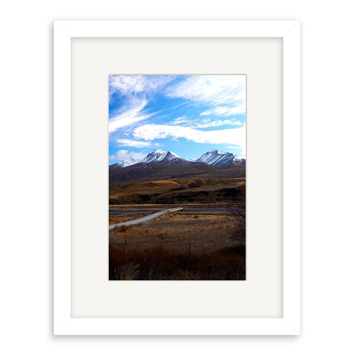The Mt Potts - RP065 is a framed photographic print of New Zealand’s snow-capped mountains, winding river, and dry grassland under a blue sky, printed on archival matte paper with white frame and mat.