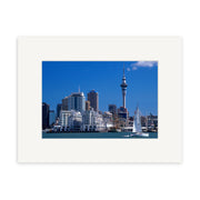 Auckland City - RP005 captures modern buildings and a tall tower across the water in New Zealand, with a sailboat under clear blue skies—perfect for stunning photographic prints on archival quality paper.