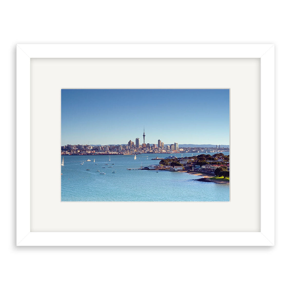 The “Devonport - RP006” is a framed photograph featuring New Zealand’s coastal city skyline, a prominent tower, buildings, and sailboats. Printed on archival matte paper, it beautifully captures the charm of New Zealand photographic prints.