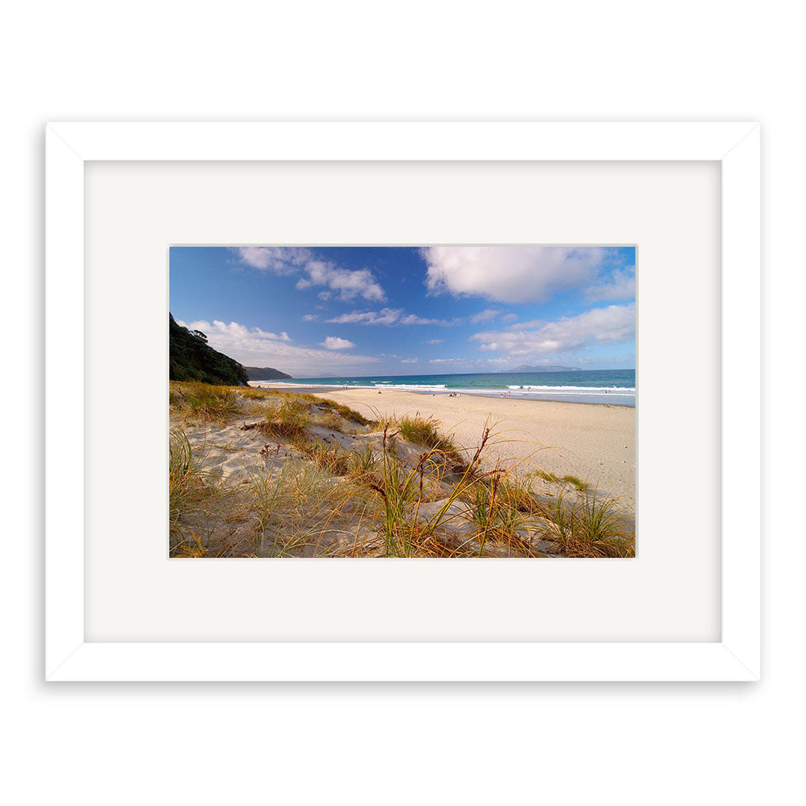 Mangawhai Beach - RP032: Framed archival-quality photographic print featuring sandy dunes, ocean waves, and a blue sky. The white frame and wide mat border add an elegant touch.