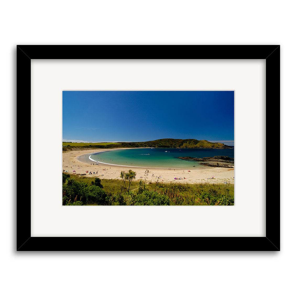 Matai Bay - RP033: A framed photo of a New Zealand beach with light sand, calm turquoise water, people swimming, and green foreground vegetation. Printed on archival quality matte paper for lasting beauty.